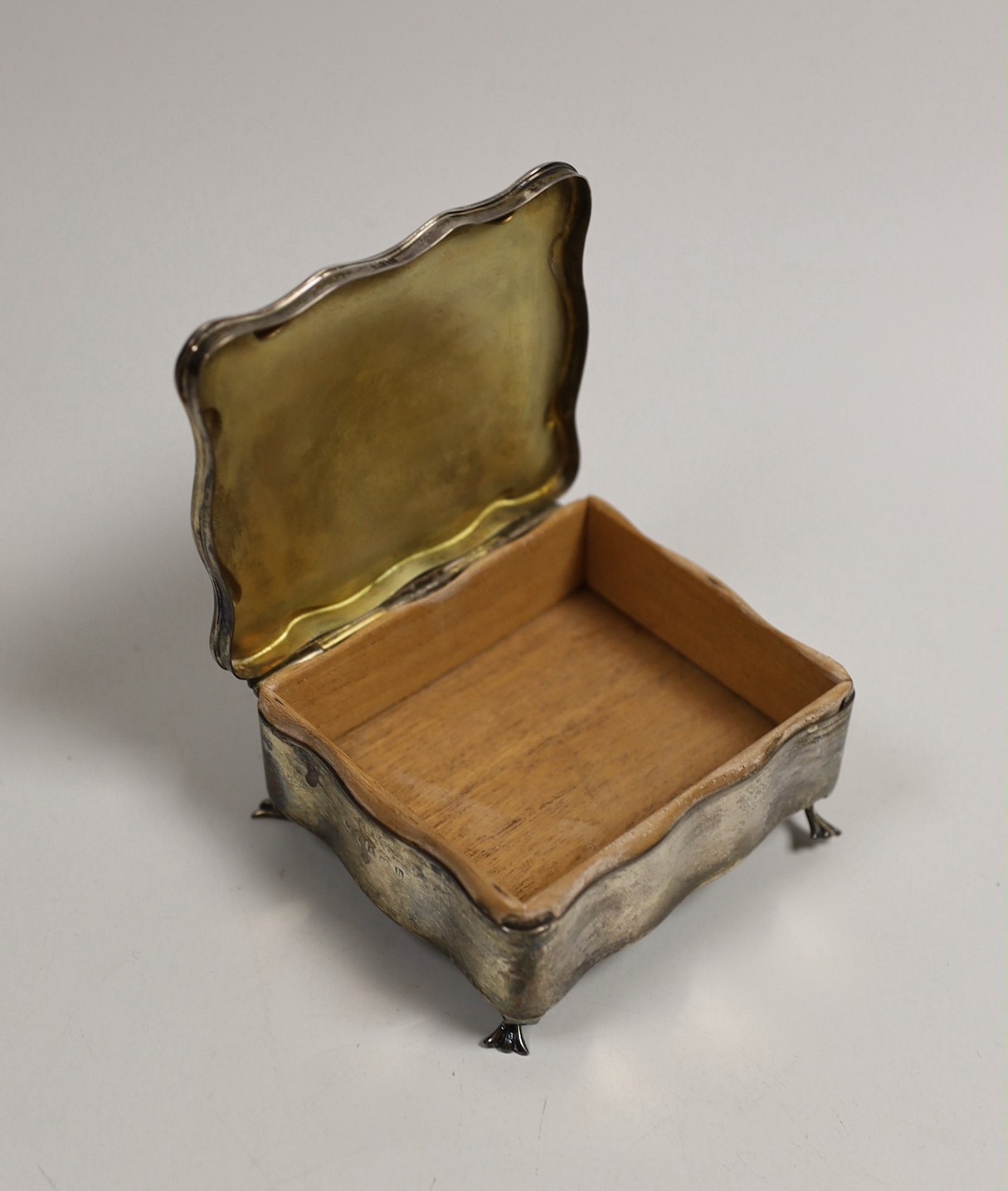 An Edwardian silver trinket box, Birmingham, 1907, 90mm, a silver cigarette case and a Persian? white metal oval box.